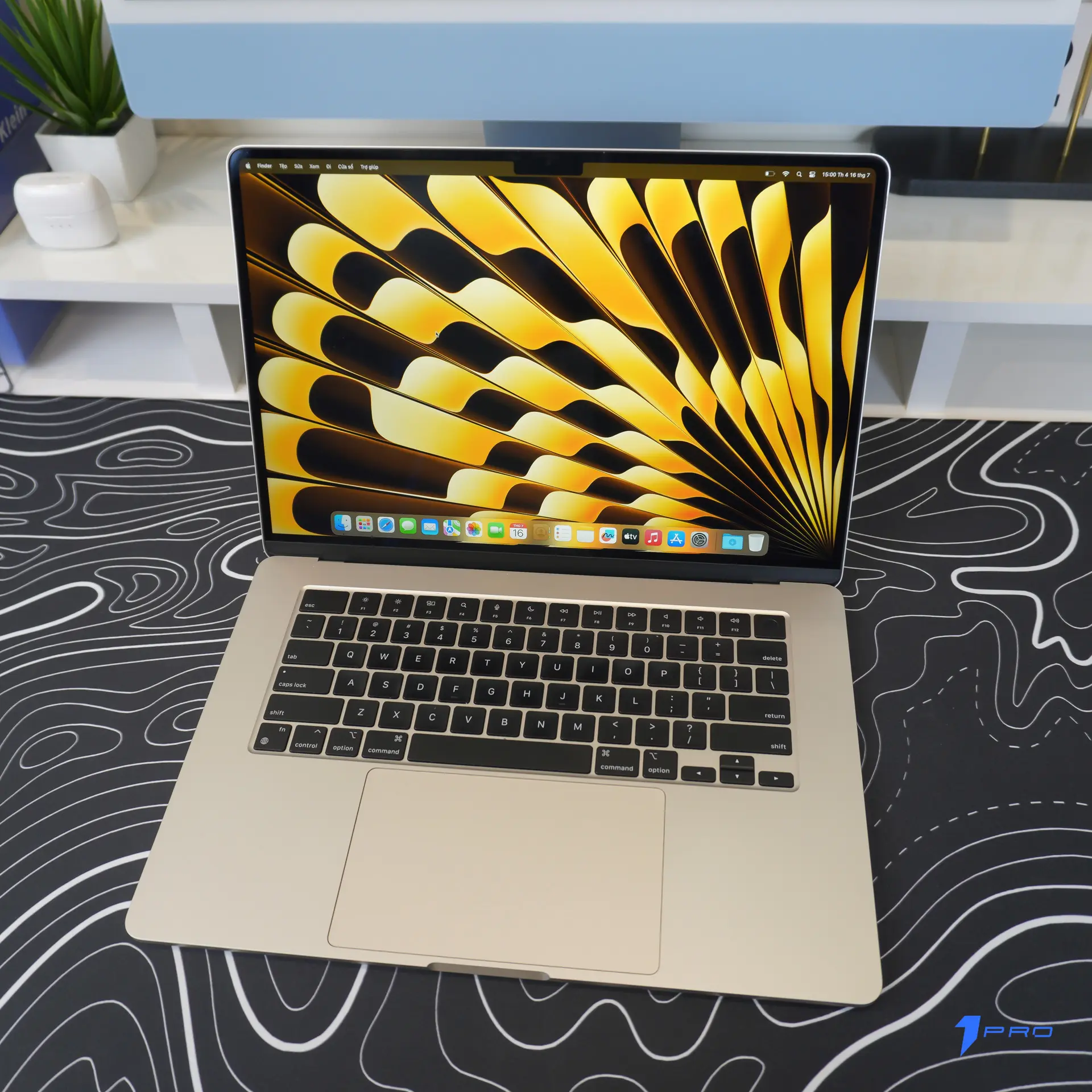 Macbook Air M2 màu Midnight nằm trên bàn làm việc gỗ